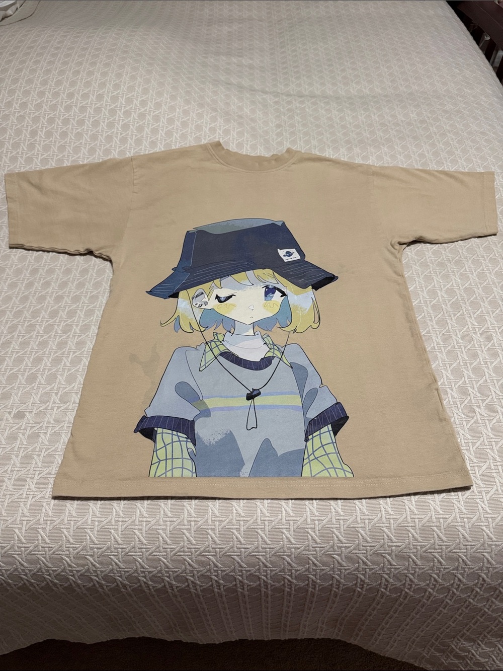 Anime girl with bucket hat. Beige t-shirt, yellow and blue colors.